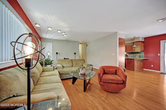 living area with light wood finished floors, baseboards, and visible vents