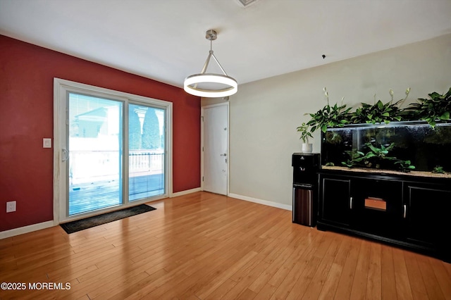 interior space with baseboards and light wood finished floors