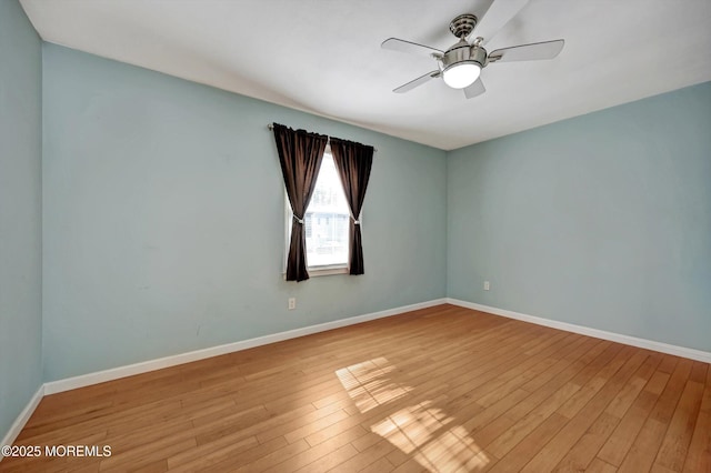 spare room with ceiling fan, wood finished floors, and baseboards