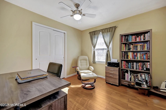 home office featuring ceiling fan, light wood finished floors, and baseboards