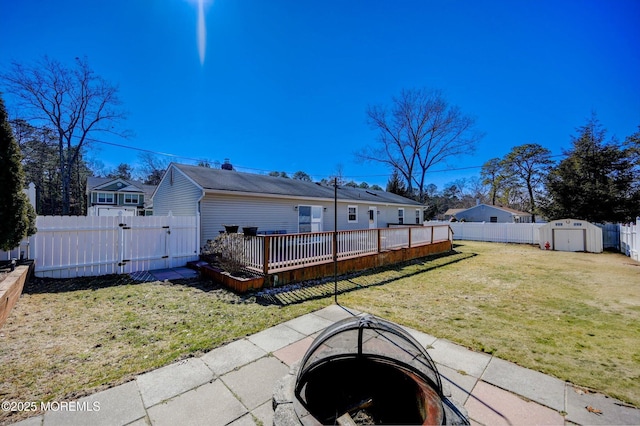 back of house featuring a yard, a gate, a shed, a fenced backyard, and an outdoor structure