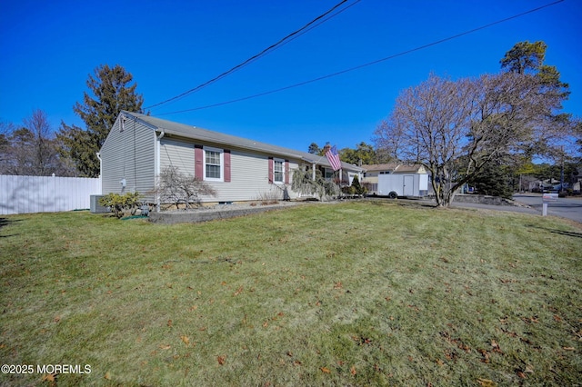 view of front of property featuring a front lawn, cooling unit, fence, and an outdoor structure