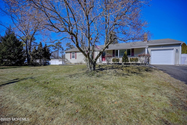 ranch-style home with driveway, an attached garage, fence, a porch, and a front yard