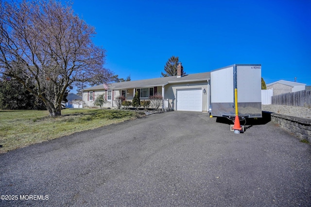 ranch-style house with a chimney, fence, driveway, and an attached garage