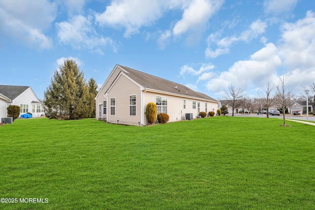 view of side of property featuring a yard and central air condition unit