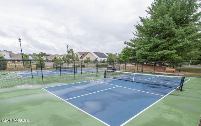 view of sport court featuring a residential view and fence