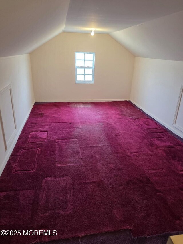 bonus room with lofted ceiling, carpet, and baseboards