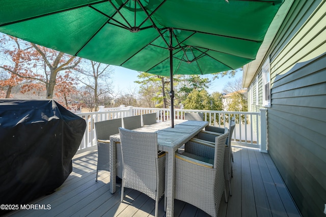 deck featuring outdoor dining space and grilling area