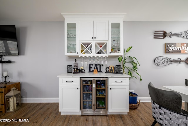 bar with a dry bar, beverage cooler, baseboards, and dark wood-style flooring