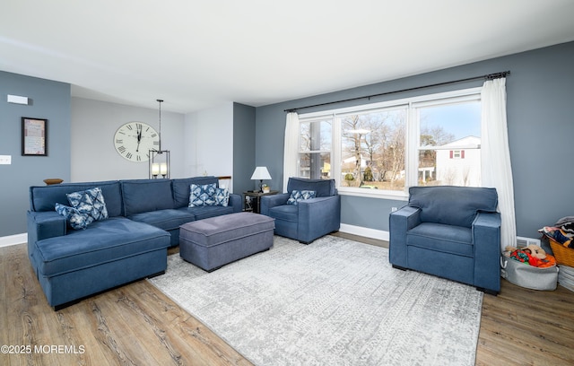 living area with baseboards and wood finished floors