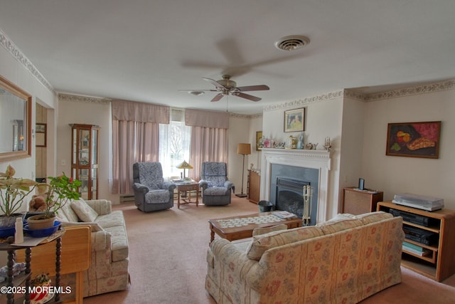 carpeted living area with a baseboard heating unit, a glass covered fireplace, visible vents, and ceiling fan