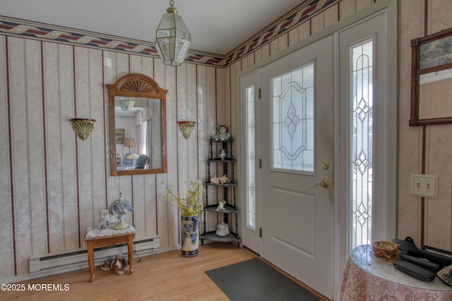 foyer with a baseboard radiator, wood finished floors, and a healthy amount of sunlight