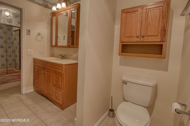 full bath with toilet, vanity, baseboards, tile patterned floors, and a stall shower