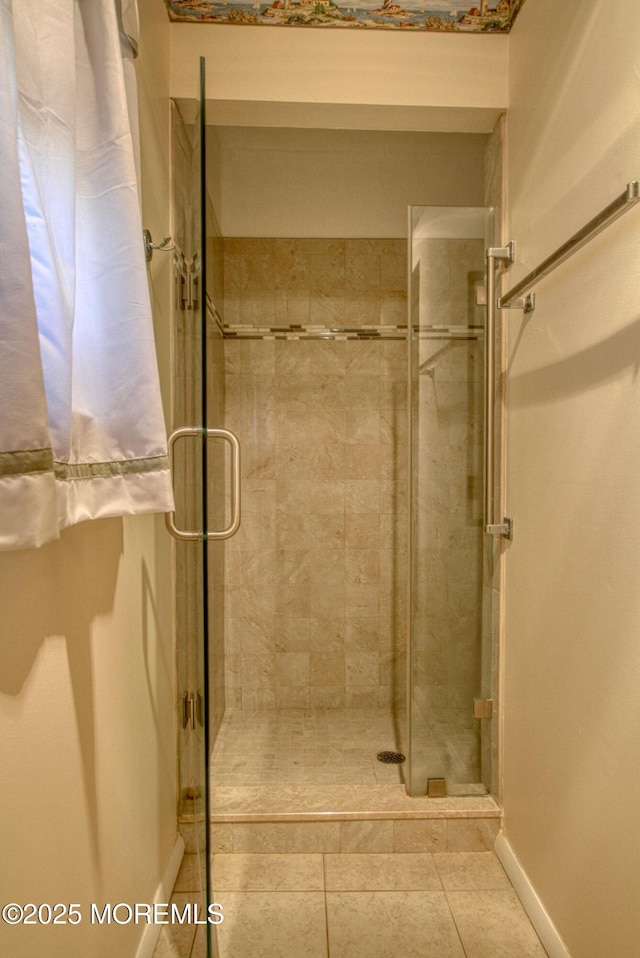 full bathroom featuring a stall shower, tile patterned flooring, and baseboards