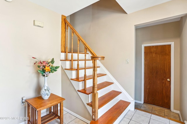 staircase featuring tile patterned flooring and baseboards