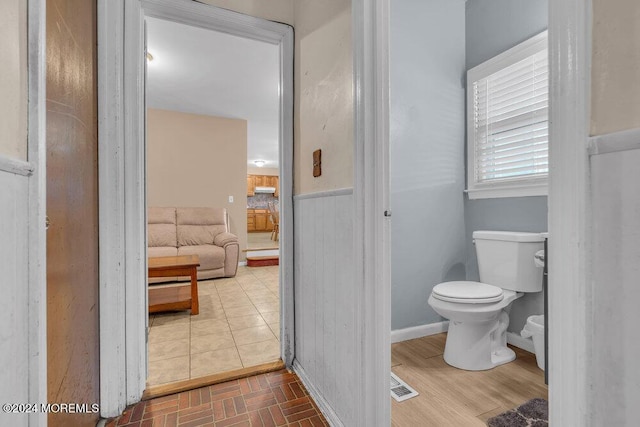 bathroom with toilet, visible vents, and wainscoting