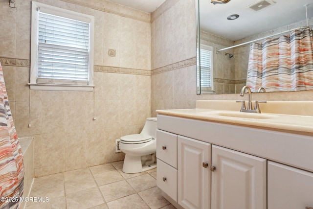 bathroom with visible vents, toilet, curtained shower, tile walls, and tile patterned flooring