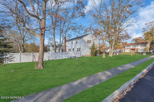 view of front of house with a front lawn and fence