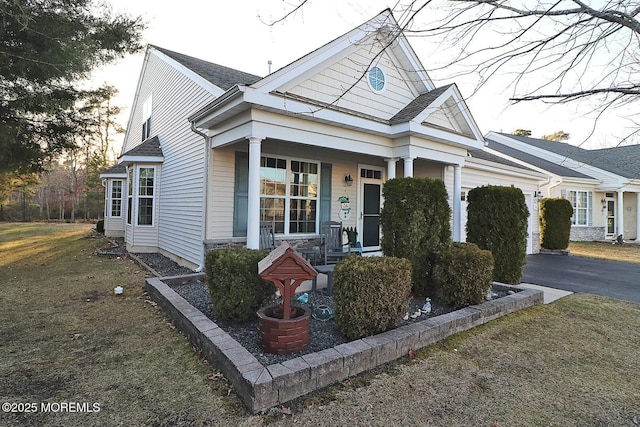 view of front of home with driveway, an attached garage, a porch, and roof with shingles