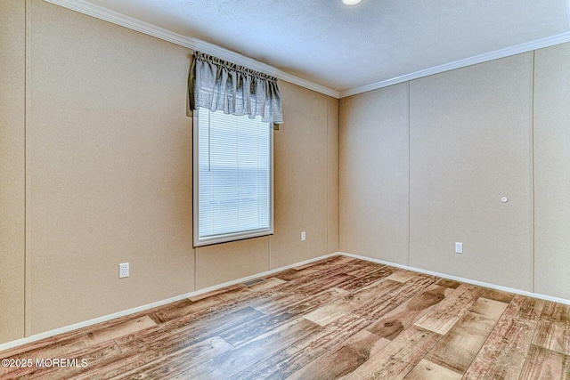 spare room featuring crown molding and wood finished floors