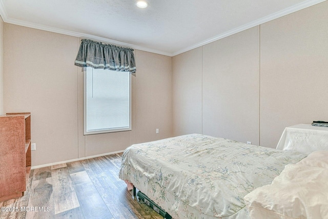 bedroom featuring a closet, wood finished floors, and crown molding