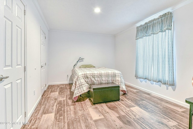 bedroom with ornamental molding, wood finished floors, and baseboards