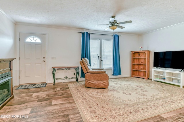 foyer entrance with a textured ceiling, ornamental molding, wood finished floors, and a healthy amount of sunlight