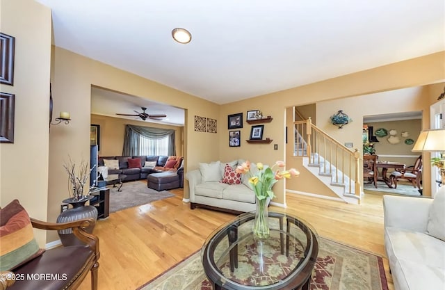 living area with stairway, baseboards, and wood finished floors