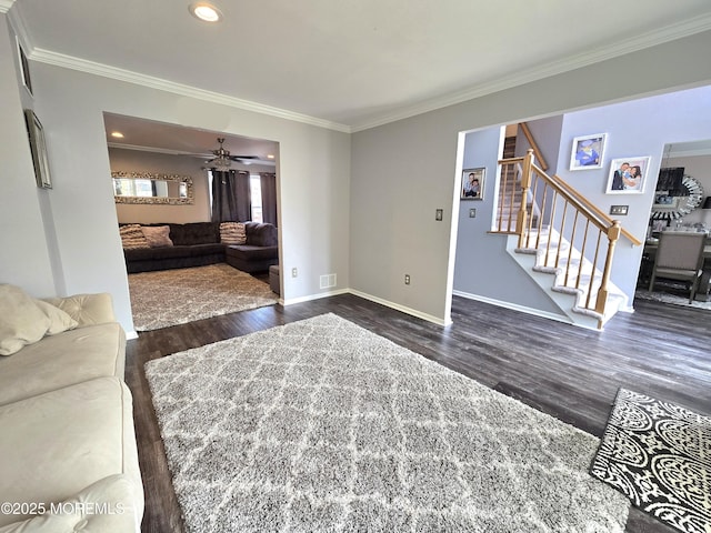 living room with crown molding, stairway, baseboards, and dark wood-style flooring