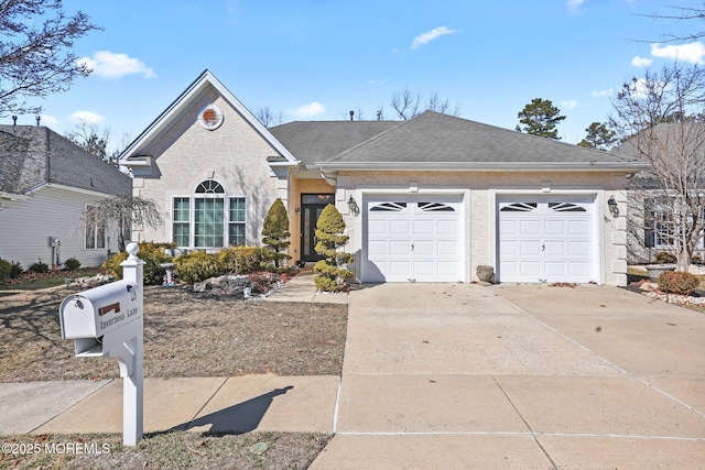 view of front of home with a shingled roof, concrete driveway, and an attached garage