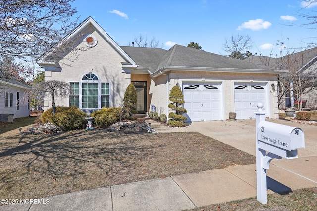 view of front of property featuring a garage, concrete driveway, and roof with shingles