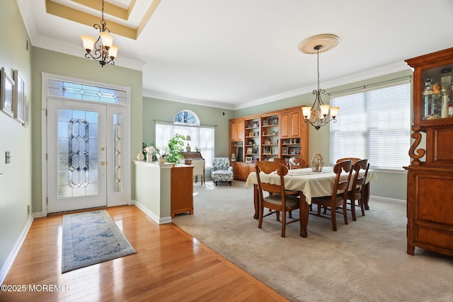 dining space featuring a chandelier, a healthy amount of sunlight, crown molding, and light wood finished floors