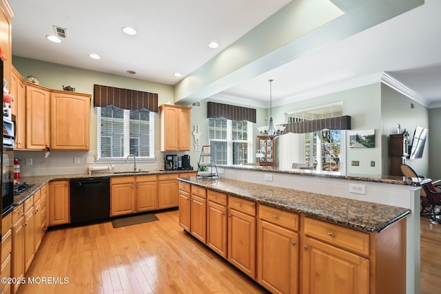 kitchen with light wood-type flooring, black dishwasher, a sink, and decorative backsplash