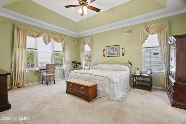 bedroom with light carpet, a tray ceiling, and visible vents