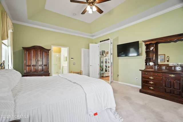 bedroom featuring connected bathroom, light carpet, a ceiling fan, baseboards, and a tray ceiling