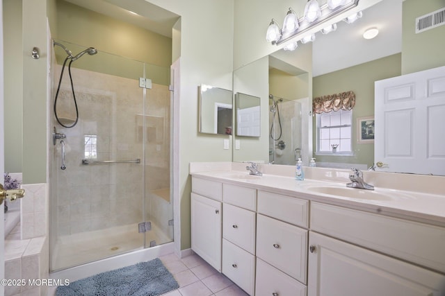 bathroom with a sink, visible vents, tile patterned floors, double vanity, and a stall shower