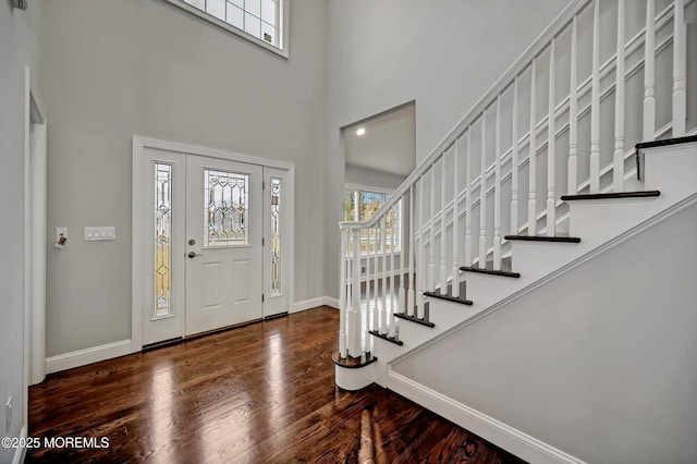 foyer featuring stairway, baseboards, a high ceiling, and wood finished floors