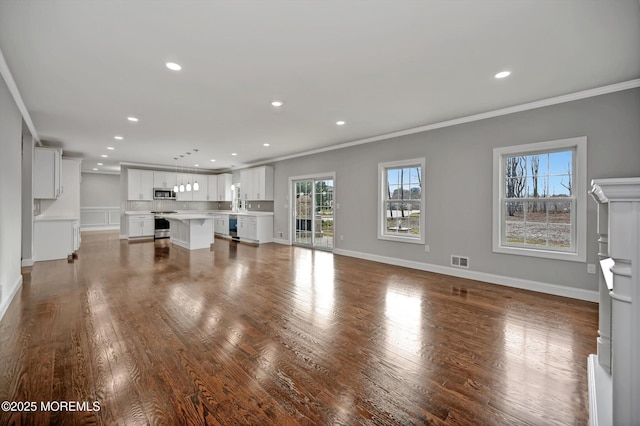 unfurnished living room featuring crown molding, recessed lighting, visible vents, and dark wood-style flooring