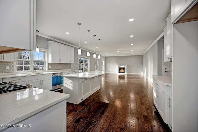 kitchen with dishwashing machine, crown molding, backsplash, and a sink