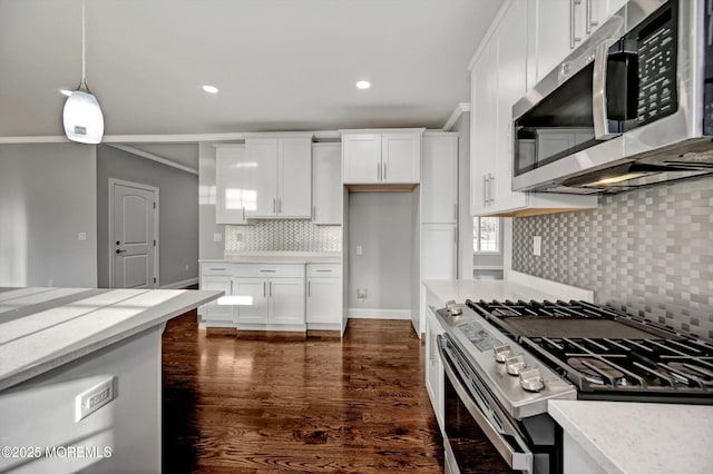 kitchen featuring light stone counters, appliances with stainless steel finishes, hanging light fixtures, white cabinets, and dark wood-style flooring