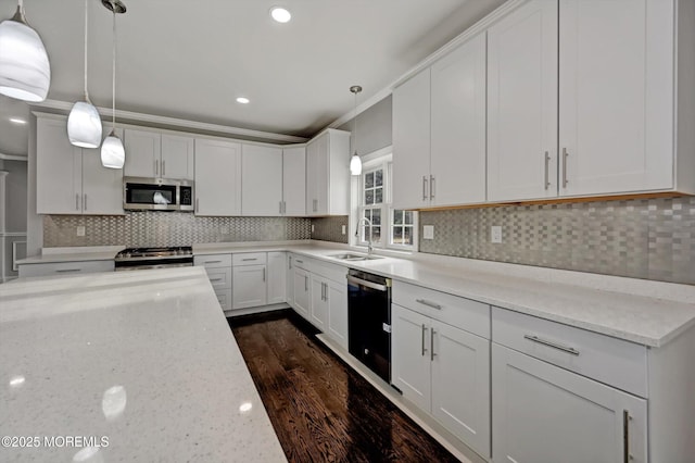 kitchen featuring a sink, tasteful backsplash, white cabinetry, stainless steel appliances, and light stone countertops