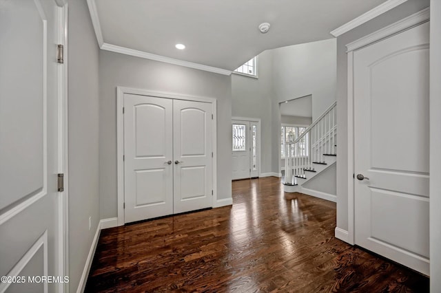 foyer featuring baseboards, dark wood-type flooring, and ornamental molding