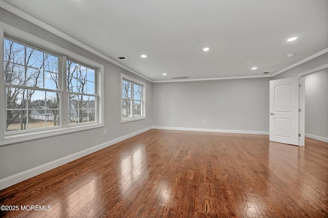 spare room with visible vents, crown molding, baseboards, and wood finished floors