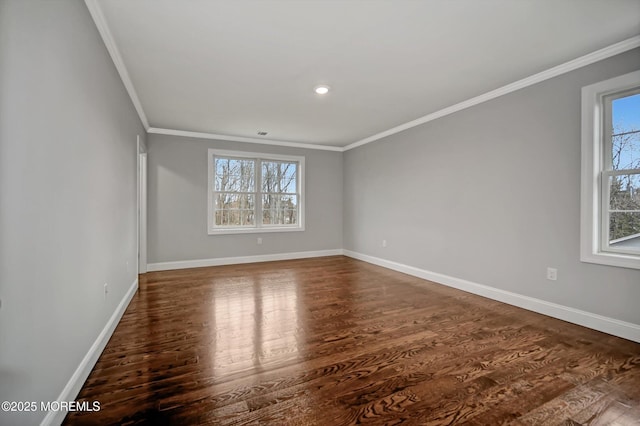 unfurnished room featuring baseboards, wood finished floors, and crown molding