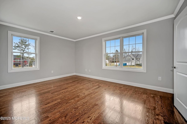 empty room featuring dark wood finished floors, baseboards, visible vents, and ornamental molding