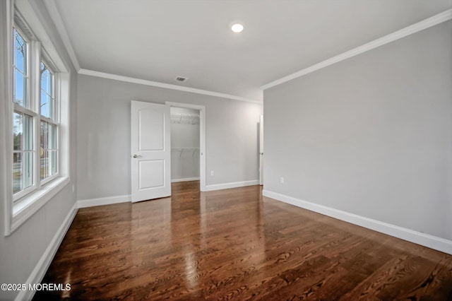 unfurnished room featuring crown molding, wood finished floors, and baseboards