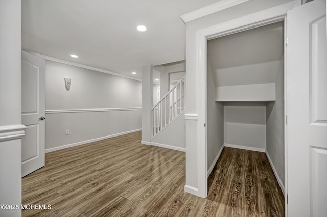 below grade area with crown molding, baseboards, stairs, recessed lighting, and wood finished floors