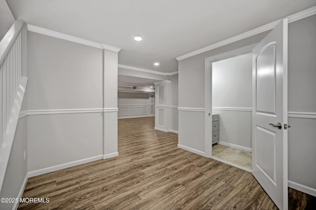 interior space featuring recessed lighting, baseboards, wood finished floors, and crown molding