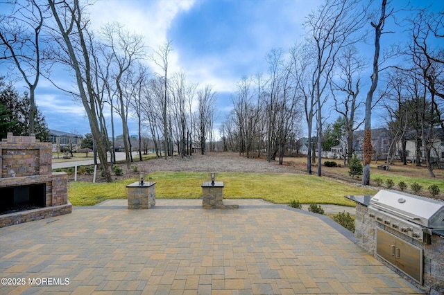 view of patio / terrace with area for grilling, exterior kitchen, and an outdoor stone fireplace