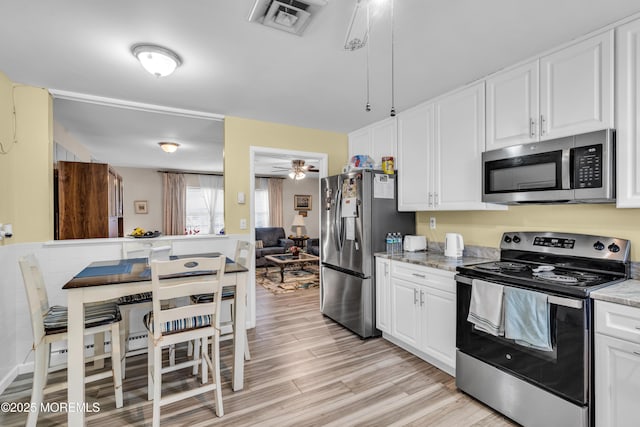 kitchen featuring white cabinetry, appliances with stainless steel finishes, and light wood-style flooring